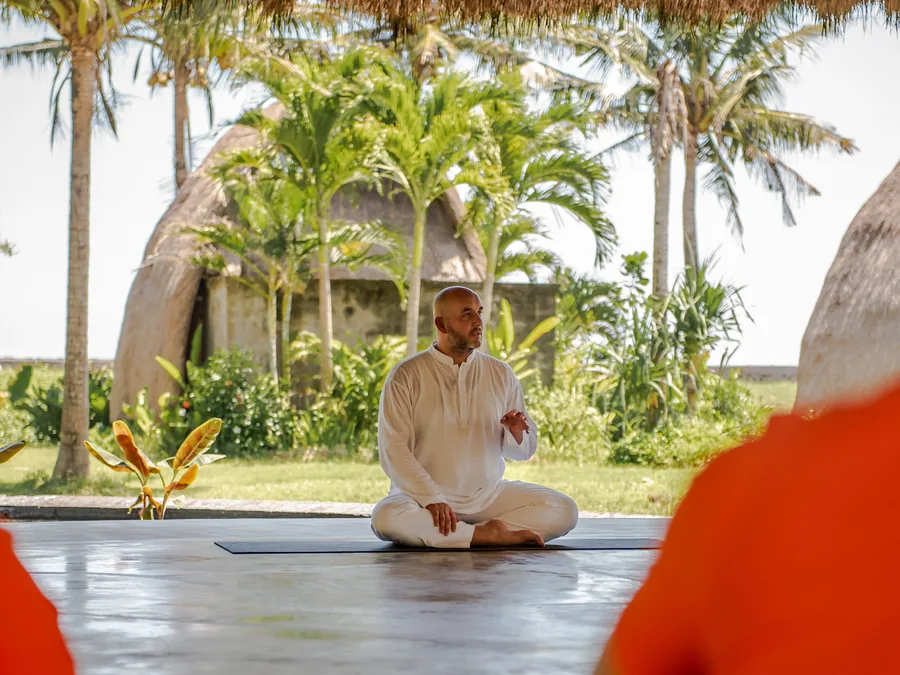 Açık havada sakin bir duruşla meditasyon yapan yoga eğitmeni