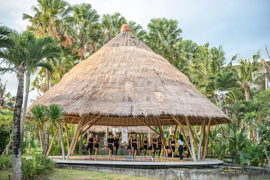 Tropik bahçenin ortasında hasır çatılı bambu yoga salonu