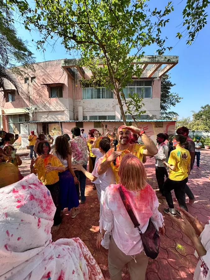 Holi kutlamasında dans eden ve renk atan kamp grubu