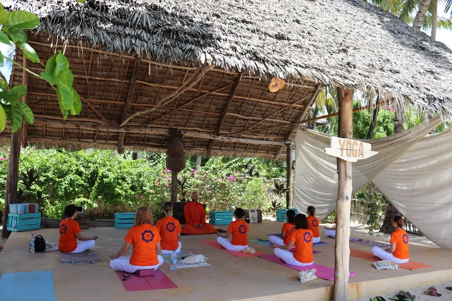 Hasır çatılı açık hava yoga salonunda ders